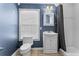 Stylish bathroom featuring blue walls, a vanity sink with a mirror, and a shower with a grey curtain at 701 S Boulevard, Tampa, FL 33606