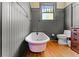 Elegant bathroom featuring paneled walls, hardwood floors, a clawfoot tub, and a classic toilet at 701 S Boulevard, Tampa, FL 33606