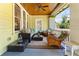 Relaxing front porch with wicker furniture, ceiling fan, and painted wood floors at 701 S Boulevard, Tampa, FL 33606