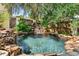 Natural rock waterfall flows into swimming pool surrounded by lush landscaping at 701 S Boulevard, Tampa, FL 33606
