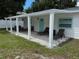 Covered back patio with white columns, gravel, seating, and lounge chairs for relaxing at 7202 8Th N Ave, St Petersburg, FL 33710