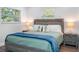 Cozy bedroom features wood laminate flooring, a rustic grey bed frame and nautical pillows at 7202 8Th N Ave, St Petersburg, FL 33710