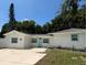 Charming single-story home with a well-maintained lawn, a light blue door and matching window trim at 7202 8Th N Ave, St Petersburg, FL 33710
