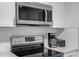 Kitchen featuring modern stainless steel appliances, white tile backsplash, and sleek countertops at 7202 8Th N Ave, St Petersburg, FL 33710
