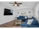 Spacious living room with hardwood floors, comfortable blue seating, and a wall-mounted television at 7202 8Th N Ave, St Petersburg, FL 33710