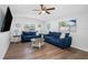 Bright living room features wood floors, a ceiling fan, two sofas, and two large windows at 7202 8Th N Ave, St Petersburg, FL 33710