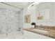 Bathroom featuring granite countertop, tiled shower with tub, and decorative lighting at 7645 Sun Island S Dr # 204, South Pasadena, FL 33707