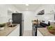 Efficient kitchen features granite countertops, white cabinetry, and black appliances at 7645 Sun Island S Dr # 204, South Pasadena, FL 33707