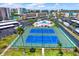 Aerial view of community tennis courts, lush landscaping, pool, parking, and high rise condo buildings at 7645 Sun Island S Dr # 204, South Pasadena, FL 33707
