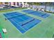 Aerial view of well-maintained tennis courts, showcasing the community's recreational amenities at 7645 Sun Island S Dr # 204, South Pasadena, FL 33707