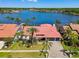 Aerial view of a home with a red tile roof on a waterfront lot with palm trees and a large boat dock at 9807 Bay Island Dr, Tampa, FL 33615
