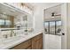 Modern bathroom featuring a dual vanity with marble countertops and a view of the outdoor patio at 9807 Bay Island Dr, Tampa, FL 33615