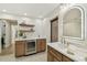 Modern bathroom features white countertops, wooden cabinetry, wine cooler, and stylish decor elements at 9807 Bay Island Dr, Tampa, FL 33615