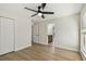Comfortable bedroom with wood floors, ceiling fan, and a view into the updated bathroom at 9807 Bay Island Dr, Tampa, FL 33615