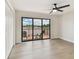 Bright bedroom with wood floors, a ceiling fan, closet, and sliding glass doors to a private balcony at 9807 Bay Island Dr, Tampa, FL 33615