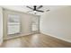 Cozy bedroom featuring wood floors, a ceiling fan, and large windows with bright natural light at 9807 Bay Island Dr, Tampa, FL 33615