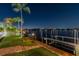 Night view of a private dock and waterfront, illuminated by landscape lighting and a starlit sky at 9807 Bay Island Dr, Tampa, FL 33615
