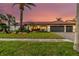 Charming one-story home with lush landscaping, a red tile roof, a three-car garage, and a paver driveway at 9807 Bay Island Dr, Tampa, FL 33615