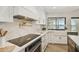 Gourmet kitchen with white cabinetry, marble backsplash and water view at 9807 Bay Island Dr, Tampa, FL 33615