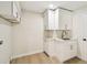 Well-lit laundry room features white cabinets, marble countertop and wood floors at 9807 Bay Island Dr, Tampa, FL 33615