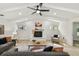 Cozy living room features a fireplace, ceiling fan, and modern decor with light colored, wood-look floors at 9807 Bay Island Dr, Tampa, FL 33615