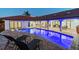 Rear view of a gorgeous pool with submerged lounge chairs and a covered patio with dining and seating areas at 9807 Bay Island Dr, Tampa, FL 33615