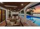 Covered outdoor patio features a pool and outdoor kitchen with waterfront views and columns at 9807 Bay Island Dr, Tampa, FL 33615