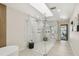 Luxurious shower with marble tile, multiple shower heads, and an open doorway to the backyard pool at 9807 Bay Island Dr, Tampa, FL 33615