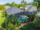 Aerial view of a home with a screened-in pool surrounded by tropical landscaping at 10418 Applecross Ln, Tampa, FL 33626