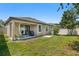 An expansive backyard featuring a covered patio and well-maintained lawn, perfect for outdoor entertaining and relaxation at 11638 Palmetto Pine St, Riverview, FL 33569
