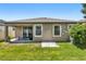 Home's backyard features a covered patio, green grass, and neutral exterior at 11638 Palmetto Pine St, Riverview, FL 33569