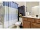 A full bathroom featuring a vanity with wood cabinets, a toilet, and a shower with blue striped curtain at 11638 Palmetto Pine St, Riverview, FL 33569