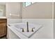 Bright bathroom features a soaking tub with white tile surround, and bronze-finished fixtures at 11638 Palmetto Pine St, Riverview, FL 33569