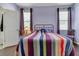 Bedroom featuring hardwood floors, dark purple curtains, and a patterned bedspread at 11638 Palmetto Pine St, Riverview, FL 33569