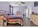 Comfortable bedroom featuring hardwood floors, a ceiling fan, and access to the en suite bathroom at 11638 Palmetto Pine St, Riverview, FL 33569