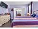 Bedroom with hardwood floors, a striped bedspread, and an open doorway into the bathroom at 11638 Palmetto Pine St, Riverview, FL 33569
