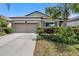 Well-maintained home featuring a two-car garage, manicured shrubs, and a gray exterior at 11638 Palmetto Pine St, Riverview, FL 33569