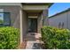 Inviting front entryway with dark-colored door, brick walkway, and lush shrubbery at 11638 Palmetto Pine St, Riverview, FL 33569