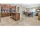 Open kitchen with granite countertops, island, and dark wood cabinetry, leading to dining area at 11638 Palmetto Pine St, Riverview, FL 33569