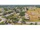 An aerial view of a residential area with well-maintained lawns, mature trees, and a golf course in the background at 1218 Haddington Cir, Sun City Center, FL 33573