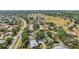Scenic aerial view of a neighborhood surrounded by lush greenery, mature trees and community amenities in a suburban setting at 1218 Haddington Cir, Sun City Center, FL 33573