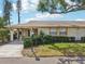 Well-maintained home featuring a covered entryway, lush landscaping, and a charming curb appeal at 1218 Haddington Cir, Sun City Center, FL 33573