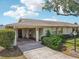 Home exterior featuring a well-maintained lawn, covered parking, and mature landscaping at 1218 Haddington Cir, Sun City Center, FL 33573