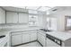Well-lit kitchen features white cabinets, updated appliances, and a convenient pass-through window at 1218 Haddington Cir, Sun City Center, FL 33573