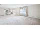 Open living room features a spacious layout, neutral carpet, and access to the kitchen at 1218 Haddington Cir, Sun City Center, FL 33573