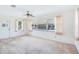 Bright living room featuring large windows, ceiling fan, and neutral-toned carpet at 1218 Haddington Cir, Sun City Center, FL 33573