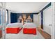 Bedroom featuring twin beds with colorful bed skirts, side table with lighting, and doorway at 14810 Rue De Bayonne # 2D, Clearwater, FL 33762