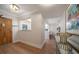 Bright hallway with hardwood floors and decorative accents, leading to an open-concept kitchen and dining area at 14810 Rue De Bayonne # 2D, Clearwater, FL 33762