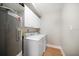 Functional laundry room with a washing machine, dryer, water heater, and storage cabinets at 14810 Rue De Bayonne # 2D, Clearwater, FL 33762