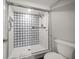 Close-up of walk-in shower with geometric pattern tile and glass door at 14810 Rue De Bayonne # 2D, Clearwater, FL 33762